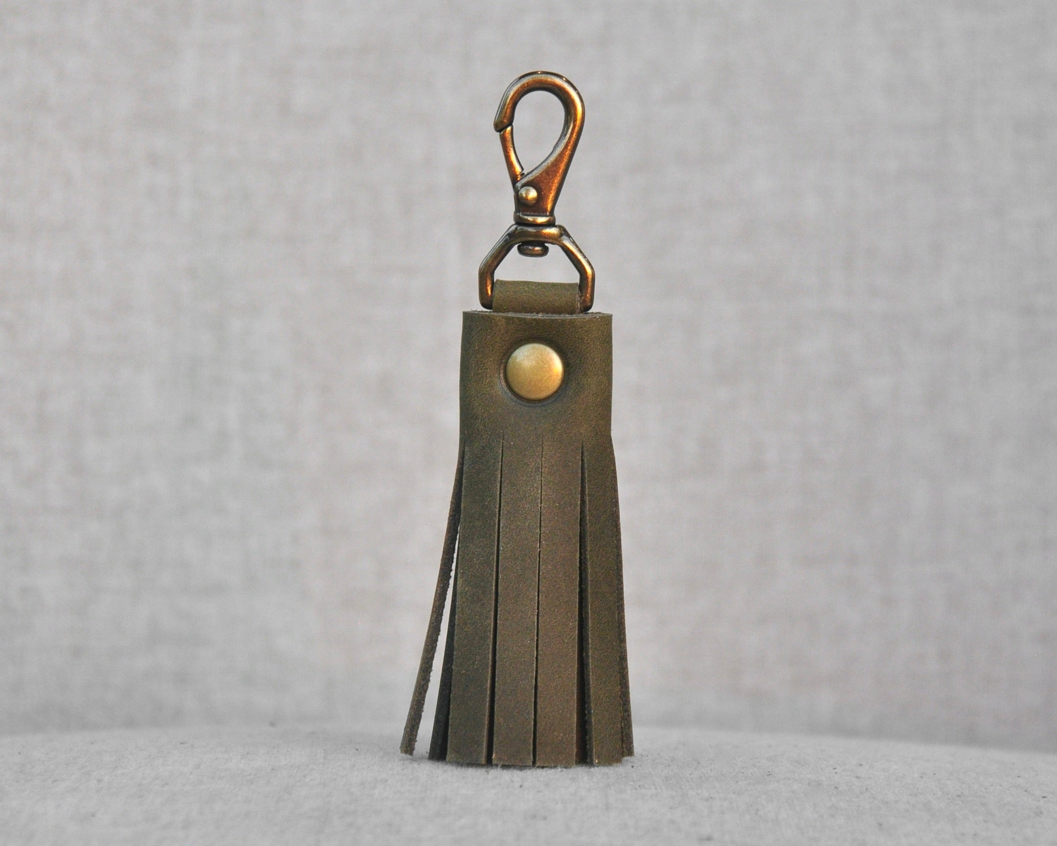 Tassel style leather purse charms with keychain hook and gold hardware in olive
