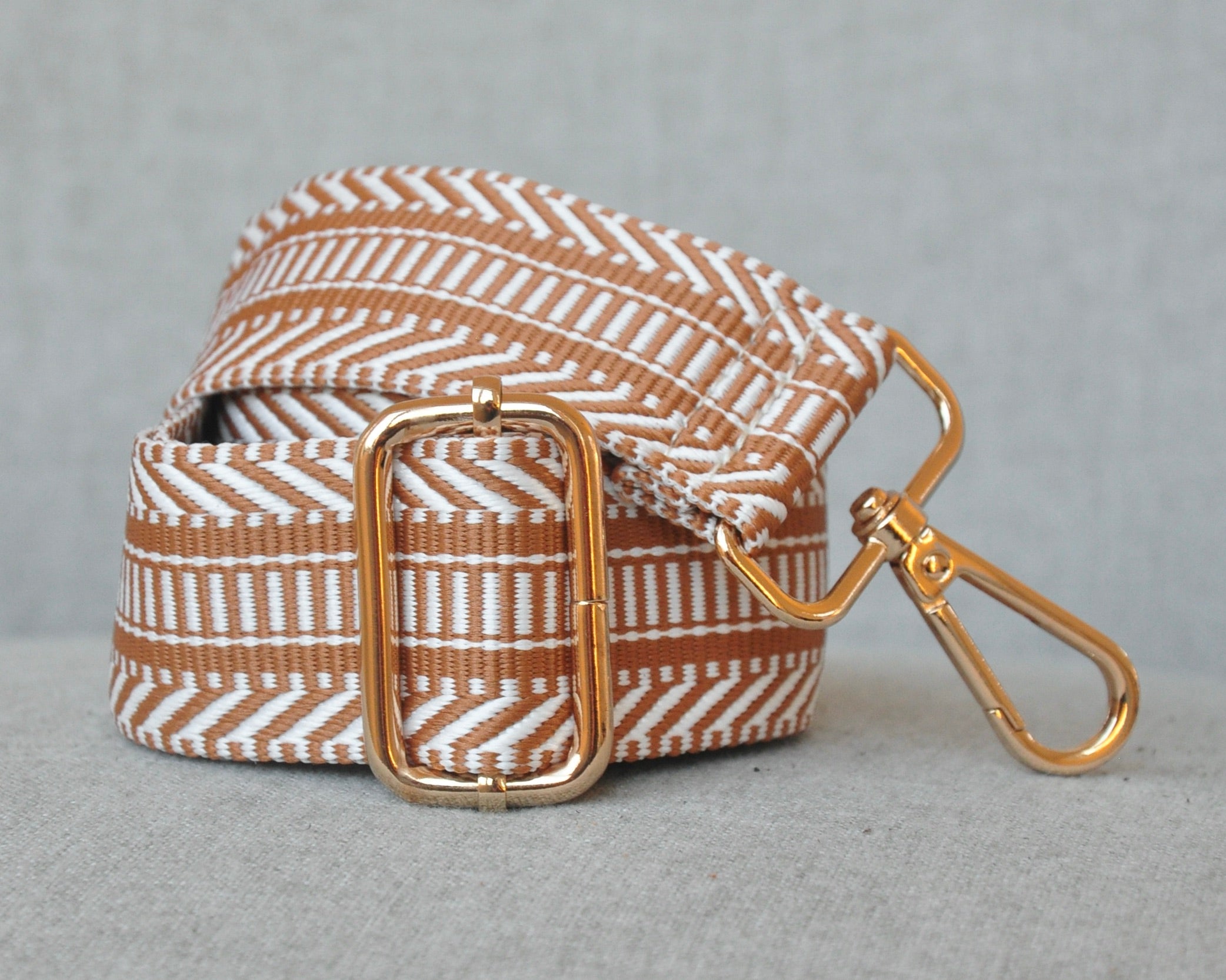 Patterned adjustable crossbody strap in neutral colors (tan, gray, and black) with gold hardware, perfect for customizing any purse or bag