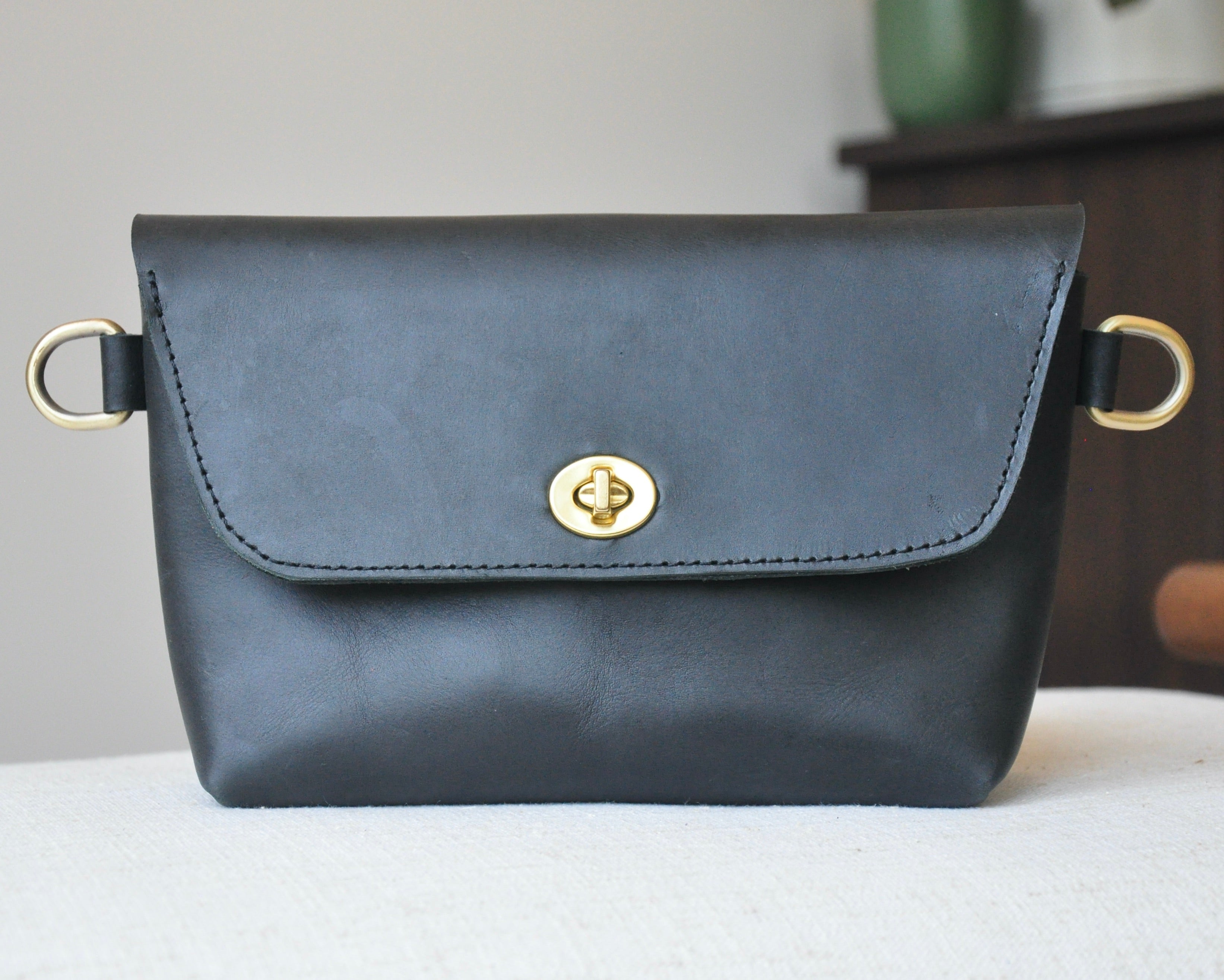 Crossbody Fanny Pack in black handmade from high-quality genuine leather with adjustable strap, brass hardware, and twist lock closure. Full-grain leather Belt Bag with pocket for phone.