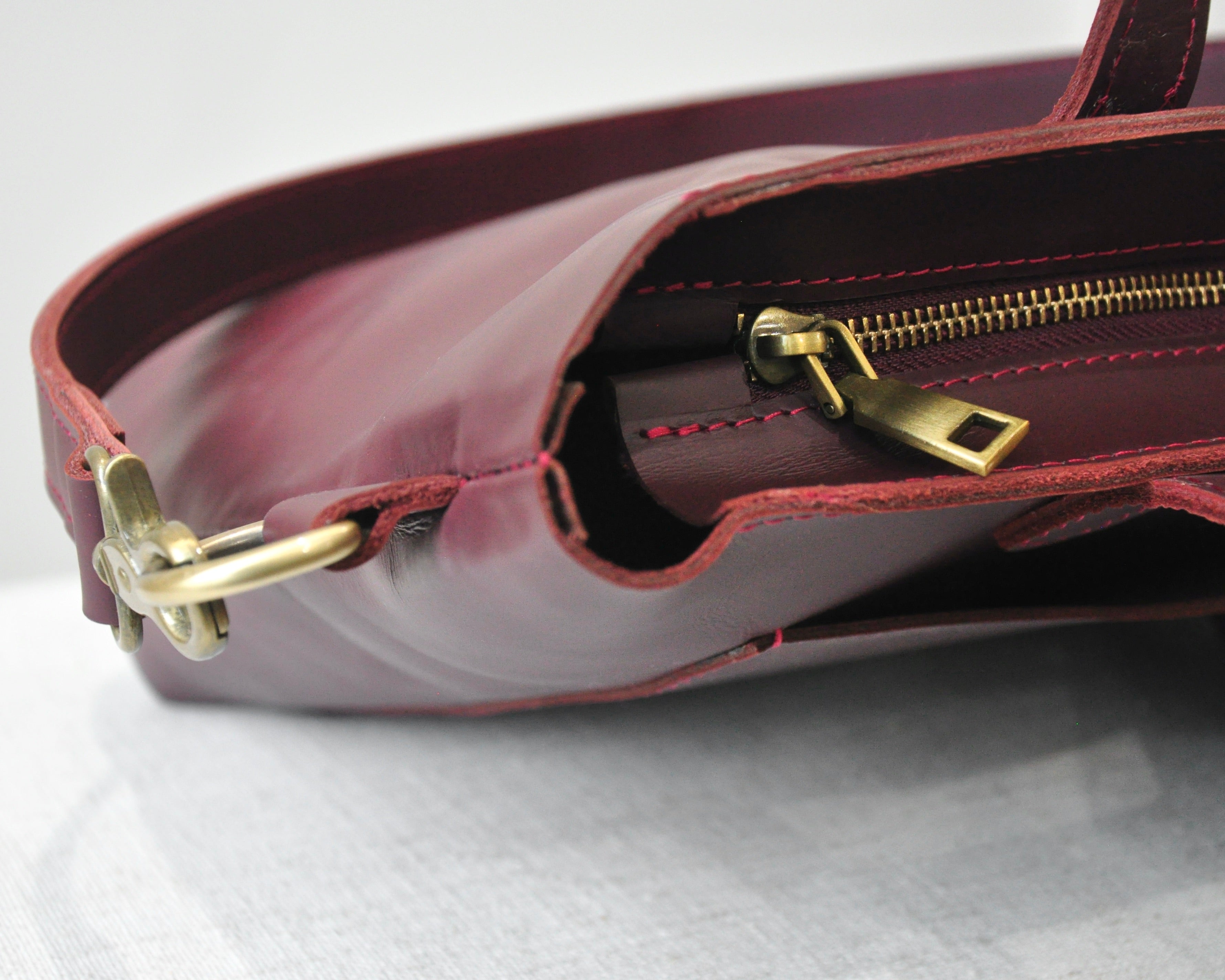 A medium sized, leather tote bag with zipper, pockets, and an adjustable crossbody strap