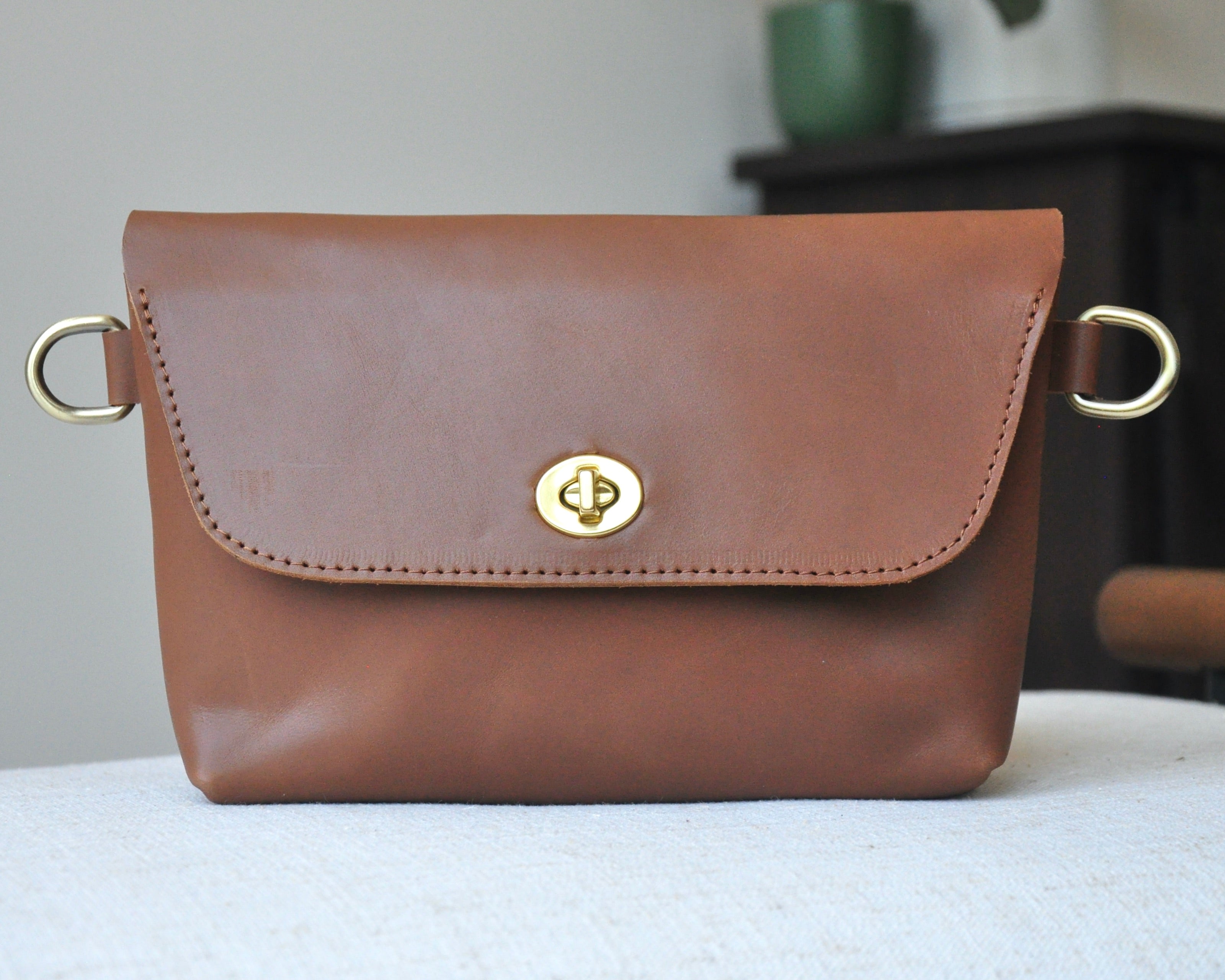 Crossbody Fanny Pack in brown handmade from high-quality genuine leather with adjustable strap, brass hardware, and twist lock closure. Full-grain leather Belt Bag with pocket for phone.