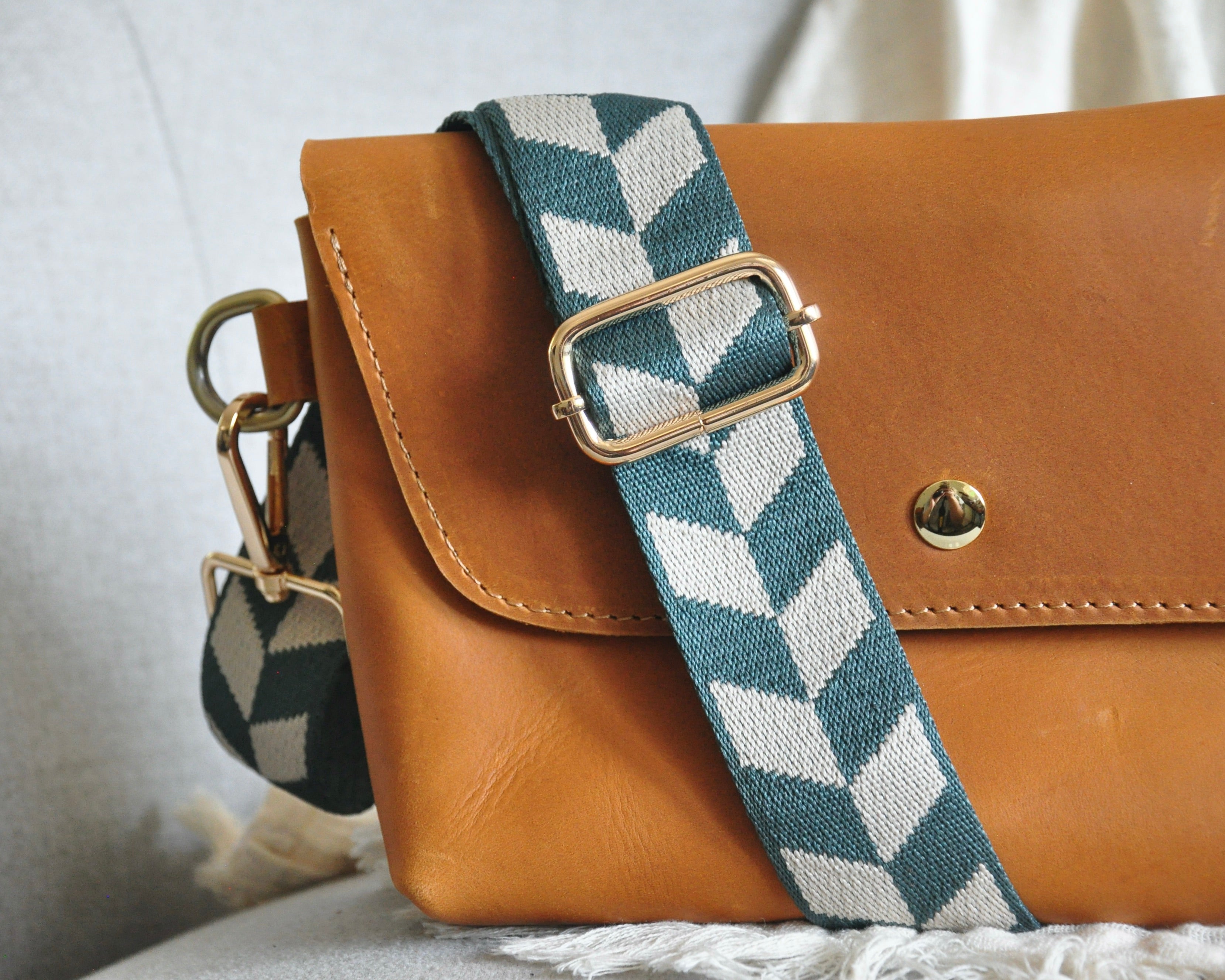 Geometric patterned adjustable crossbody strap in vibrant colors (orange, red, and blue) with gold hardware, perfect for customizing any purse or bag