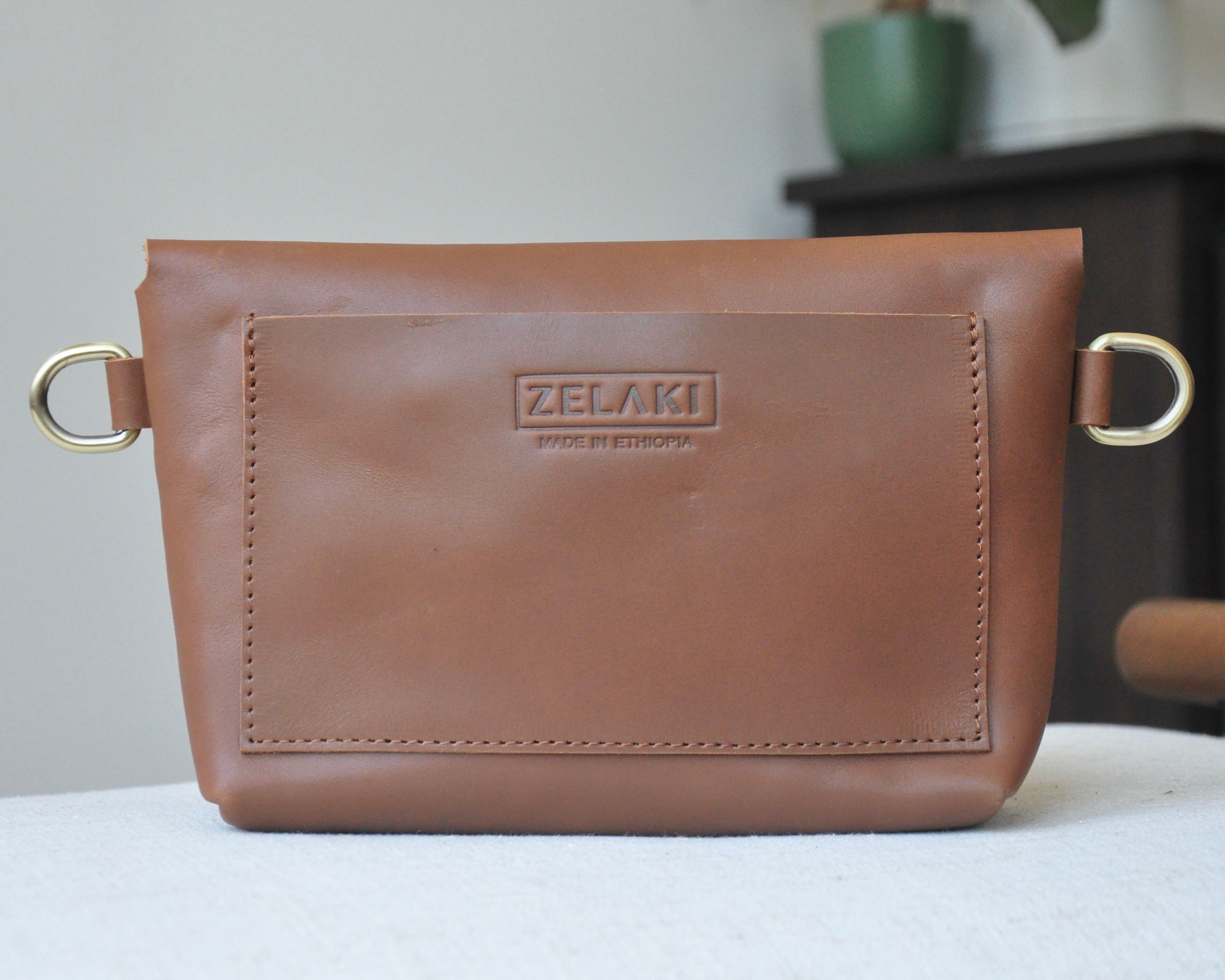 Crossbody Fanny Pack in brown handmade from high-quality genuine leather with adjustable strap, brass hardware, and twist lock closure. Full-grain leather Belt Bag with pocket for phone.