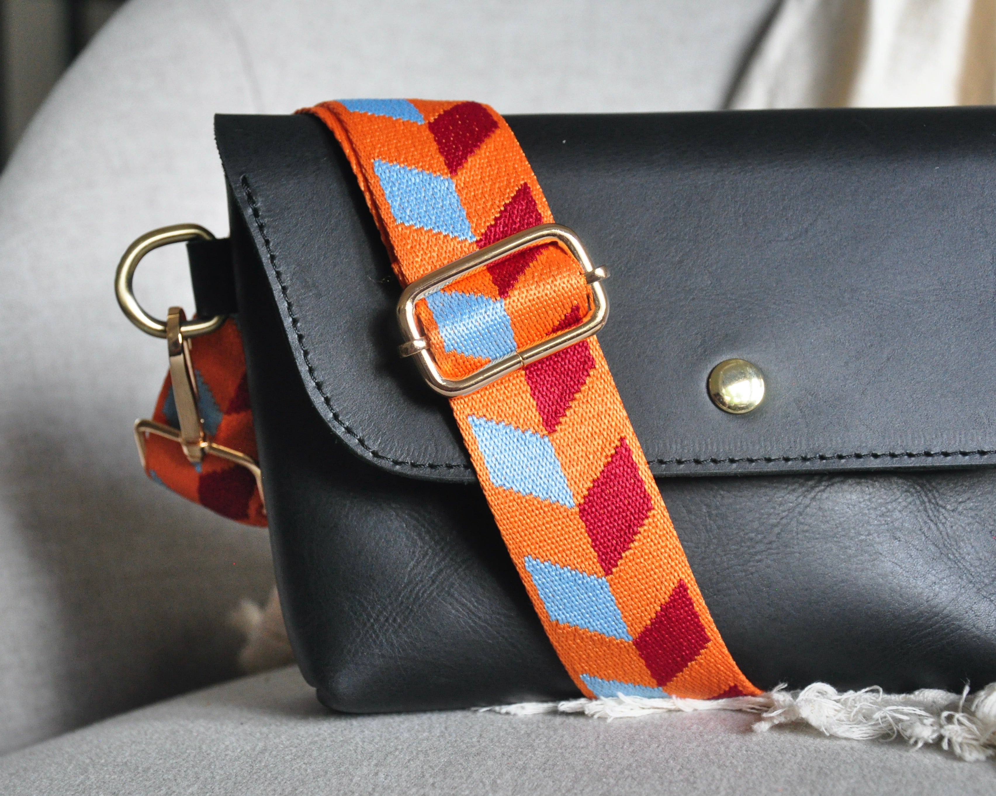 Geometric patterned adjustable crossbody strap in vibrant colors (orange, red, and blue) with gold hardware, perfect for customizing any purse or bag