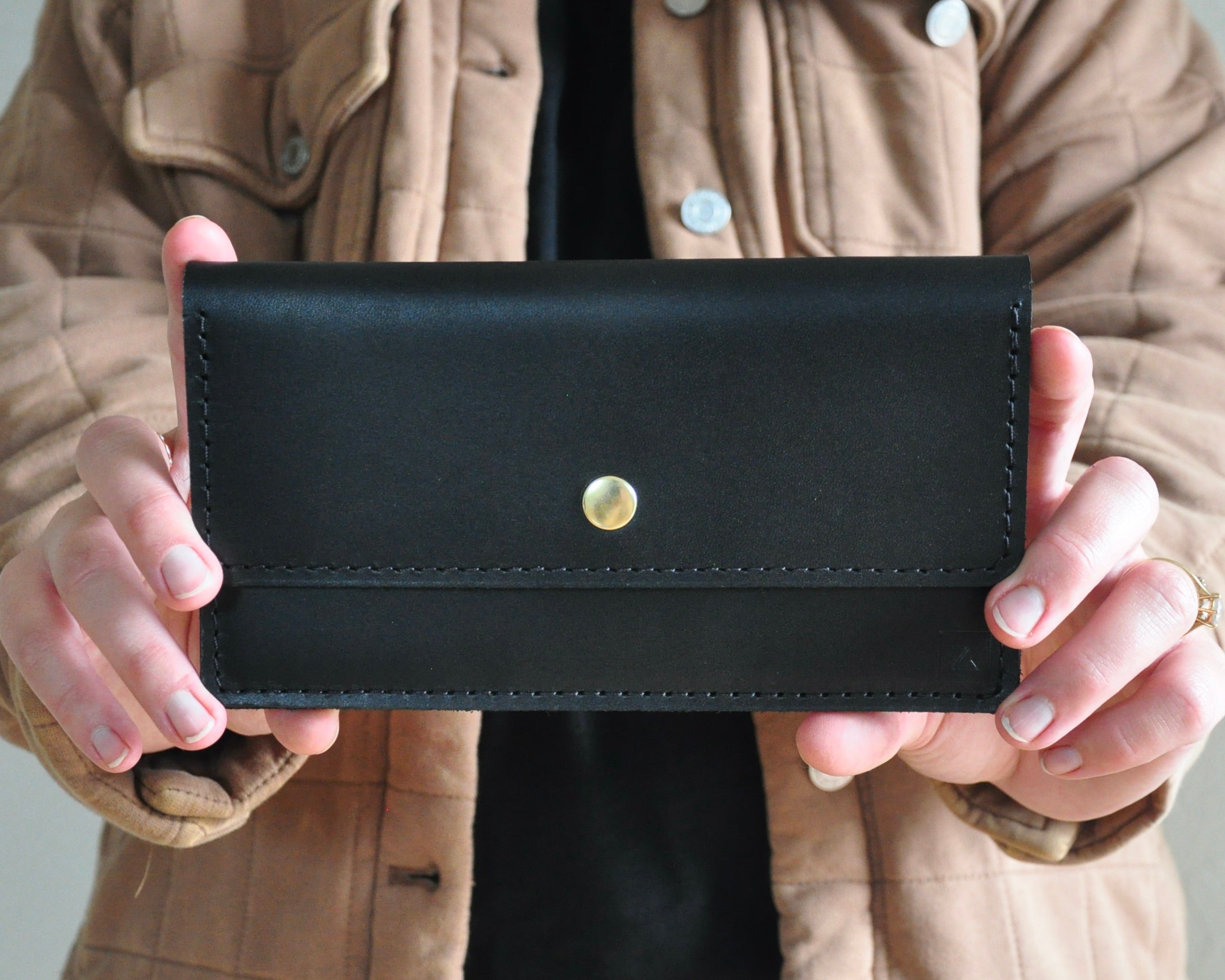 Picture of Black Leather Wallet Clutch with Brass Snap in a womans hands