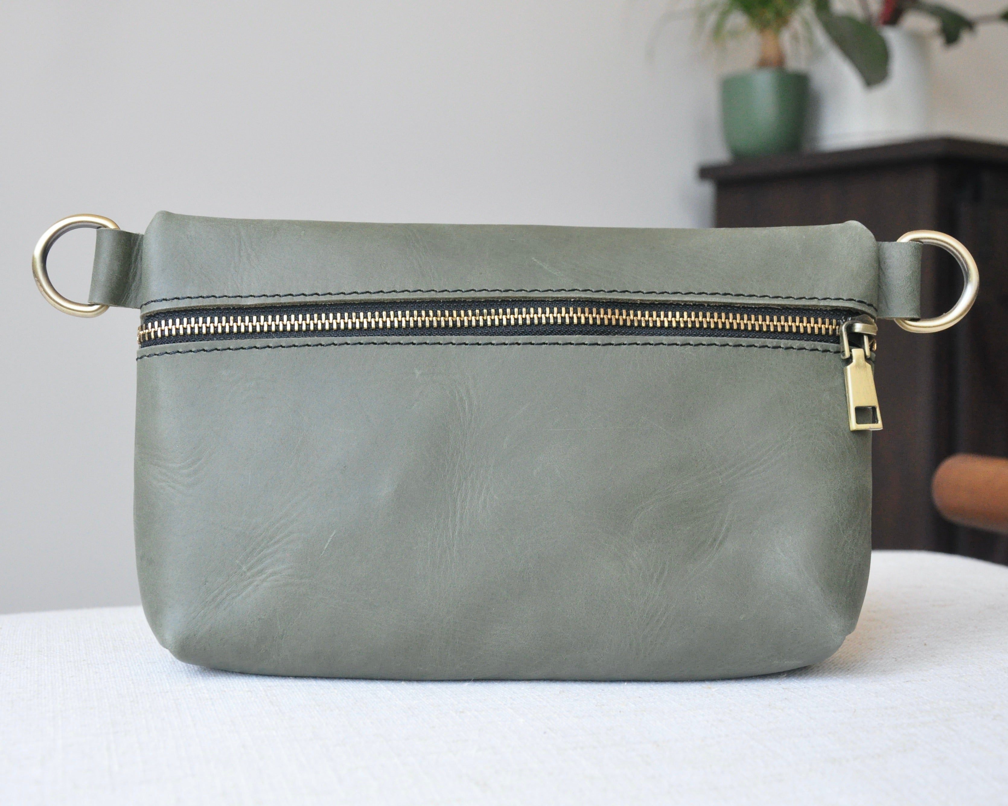 Crossbody Fanny Pack in olive green handmade from high-quality genuine leather with adjustable strap, brass hardware, and zipper closure.