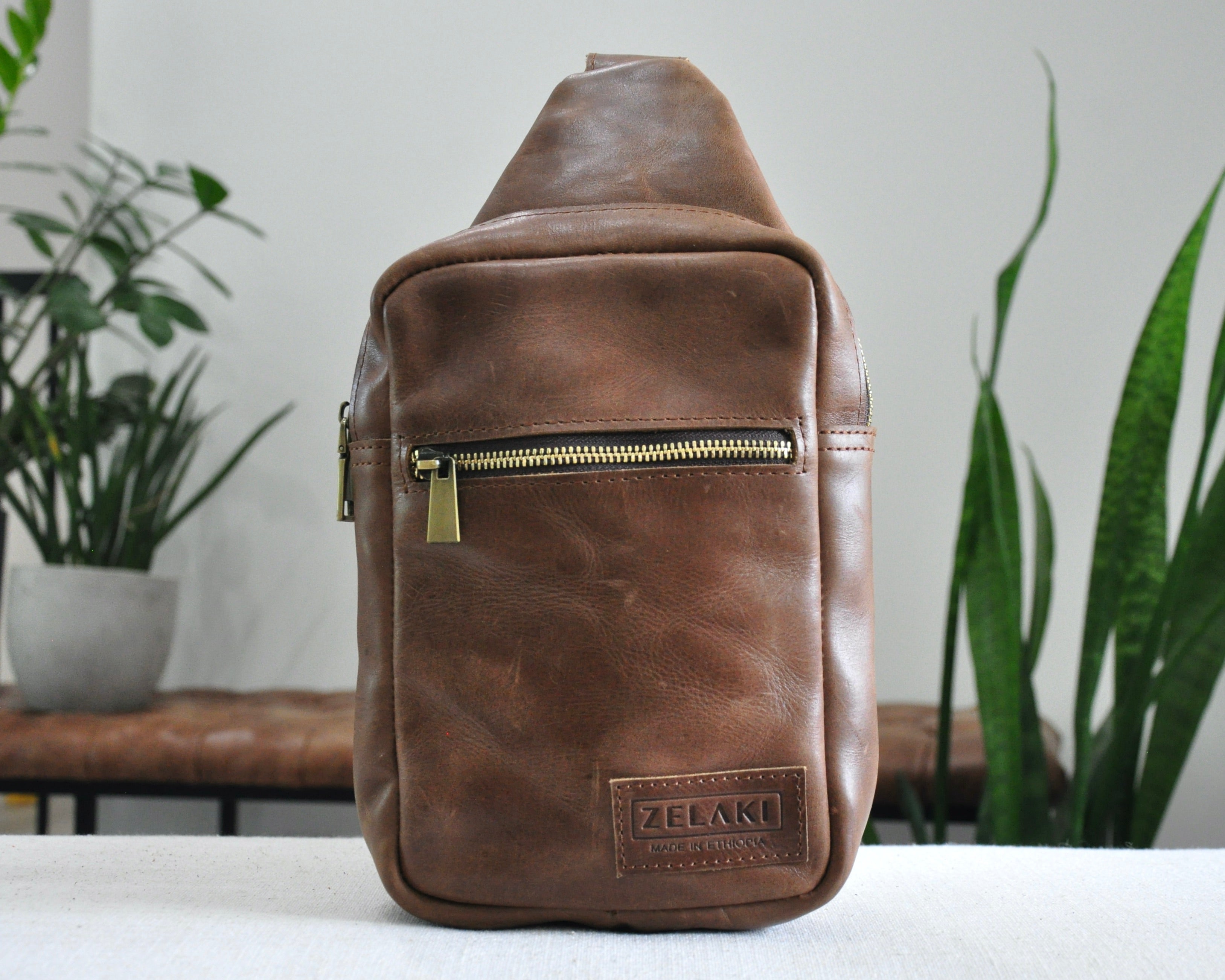 Full Grain genuine leather sling bag with adjustable strap and unisex design ethically and sustainably handmade in ethiopia in brown, tan, and olive green