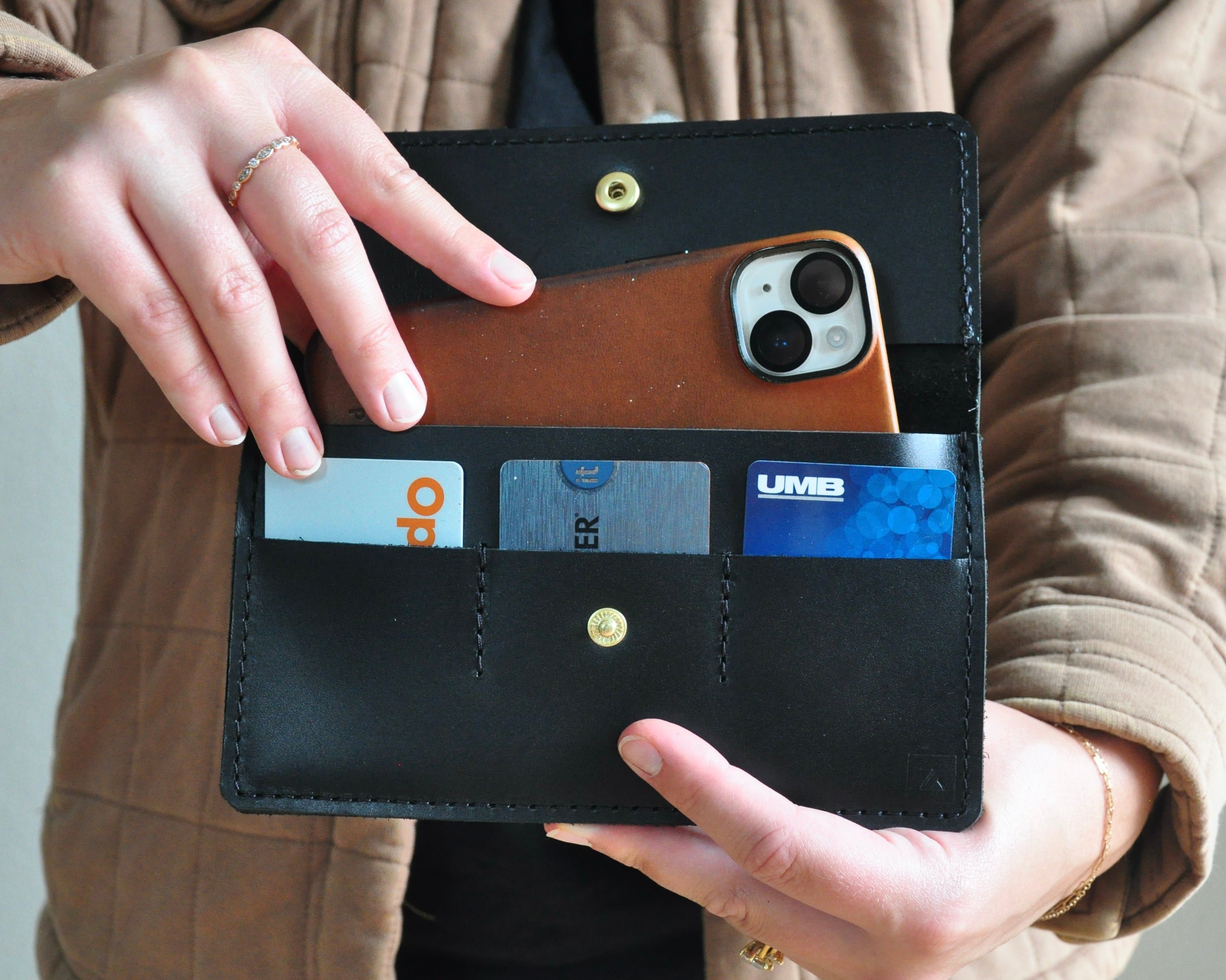 Picture of Black leather wallet clutch that fits phone, cash, and cards with gold snap closure