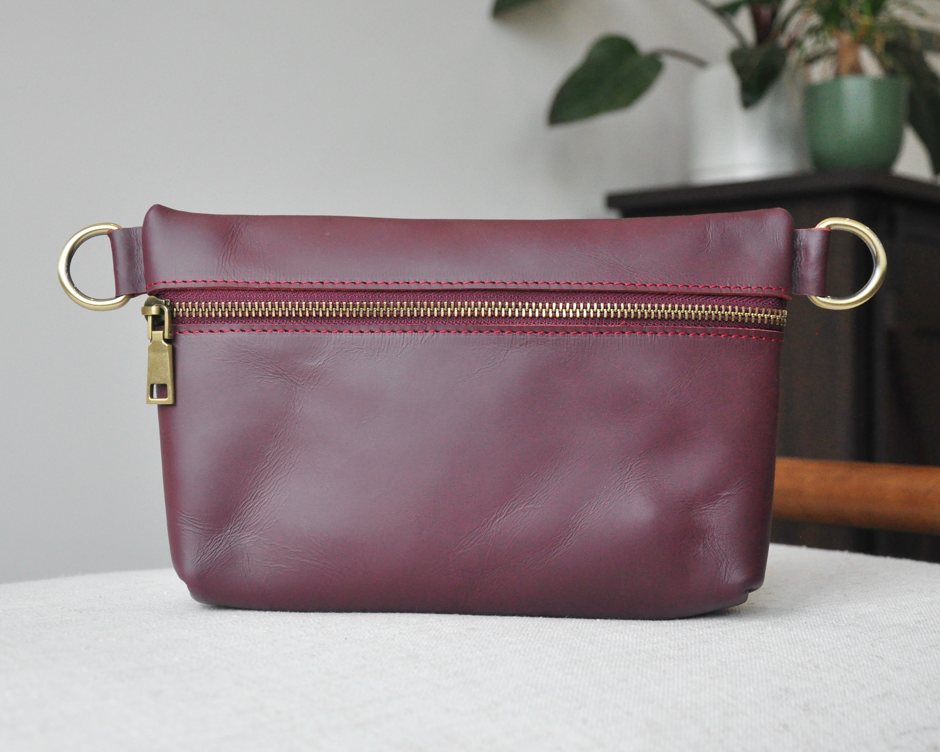 Crossbody Fanny Pack in burgundy handmade from high-quality genuine leather with adjustable strap, brass hardware, and zipper closure. Full-grain leather Belt Bag with pocket for phone