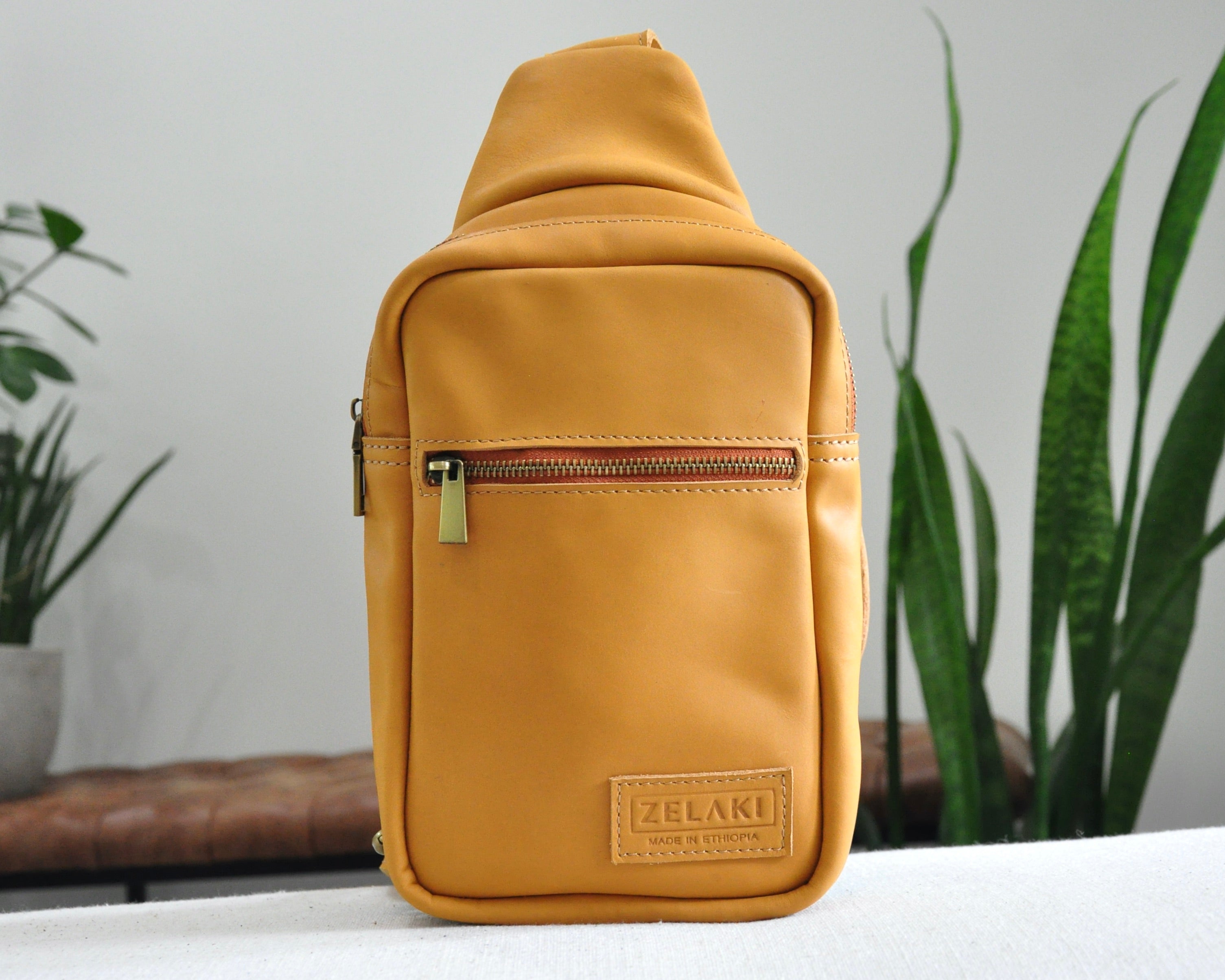 Full Grain genuine leather sling bag with adjustable strap and unisex design ethically and sustainably handmade in ethiopia in brown, tan, and olive green