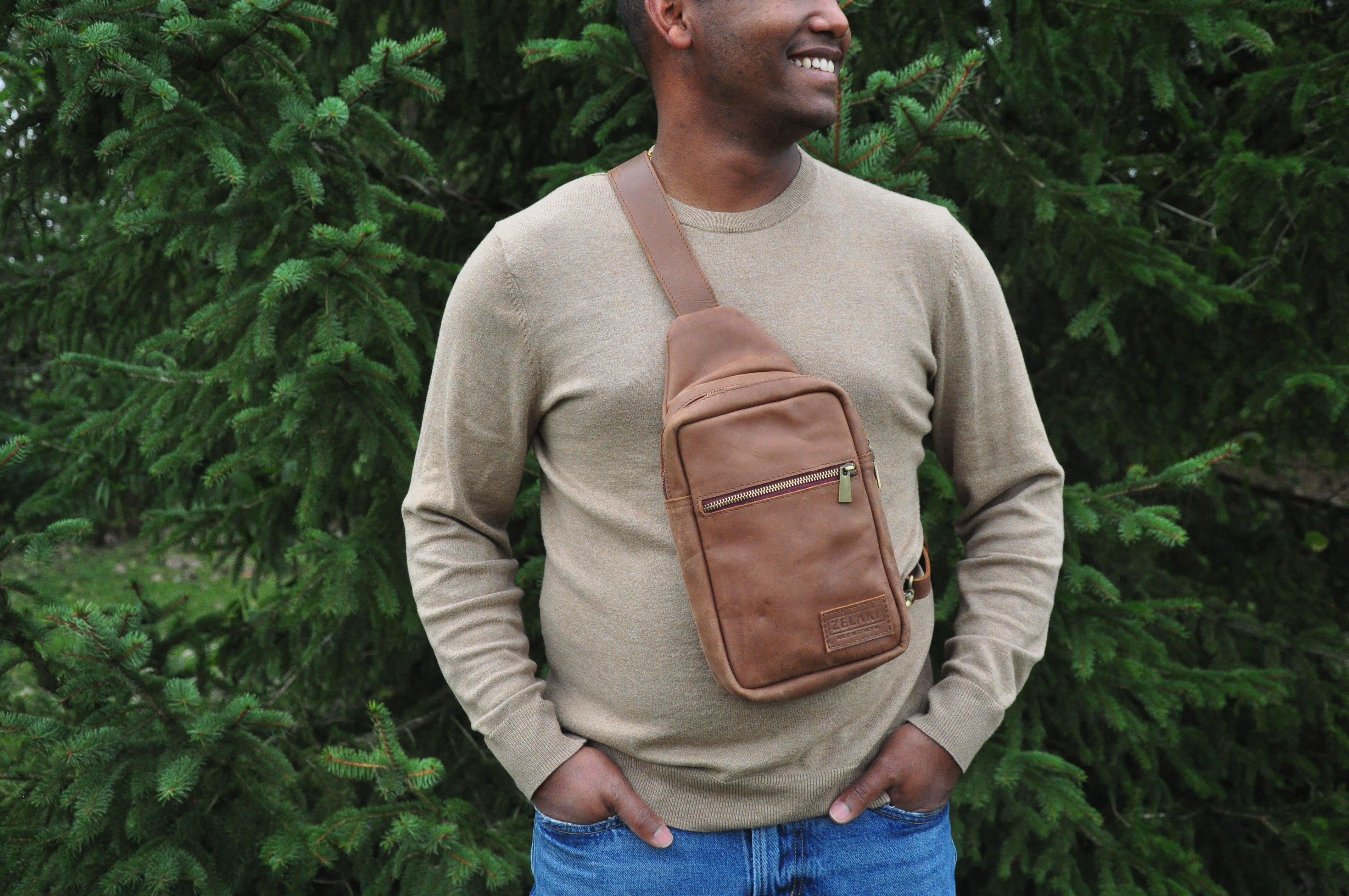 Full-grain Leather sling bag with multiple pockets, designed for versatile wear as a crossbody on your front or back, small to medium size in brown